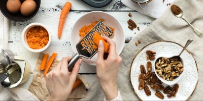 Žena strouhá mrkev na pečení