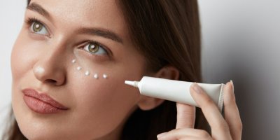 Žena si dává oční krém na obličej