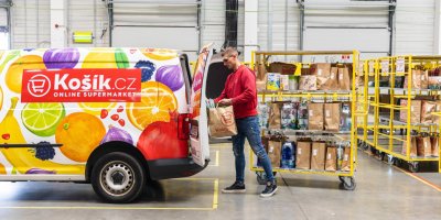Kurýr Košík.cz nakládá ve skladu nákup do auta