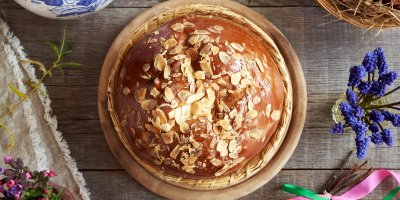 Velikonoční mazanec na stole s květinami a dalšími dekoracemi