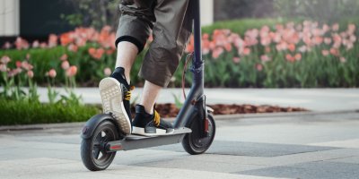 Záběr na nohy stojící na elektrické koloběžce
