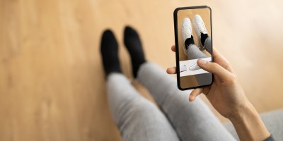 Člověk si virtuálně zkouší boty na své nohy prostřednictvím telefonu