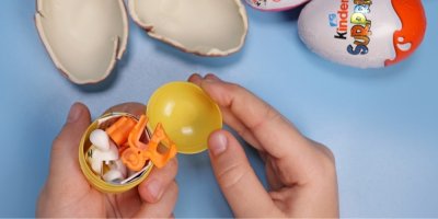 Dítě rozlamuje Kinder vajíčko, aby se dostalo k hračce