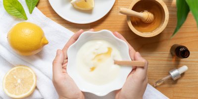 Příprava domácí masky na vlasy, v pozadí citron, med a olej