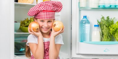 Dívka drží cibule před lednicí