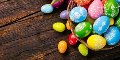 Barevné kraslice v košíku a kolem něj