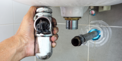 Nečistoty ucpávající odpadní sifon u umyvadla