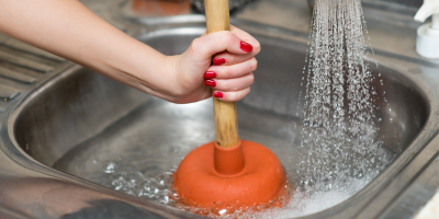 Žena čistí dřez pomocí zvonu