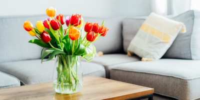 Tulipány ve váze na stolku před pohovkou