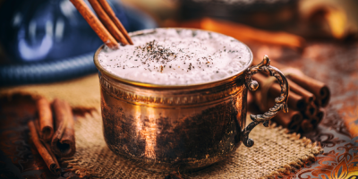 Chai latte v měděném hrnku se skořicí