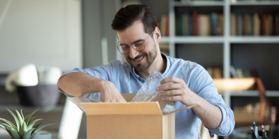 Muž rozbaluje krabici 