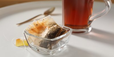 Sklenička s čajem a dvojice vylouhovaných sáčků