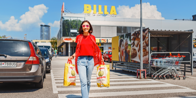 Žena nese tašky ze supermarketu Billa