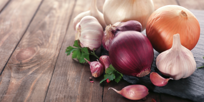 Česnek a cibule na dřevěném stole
