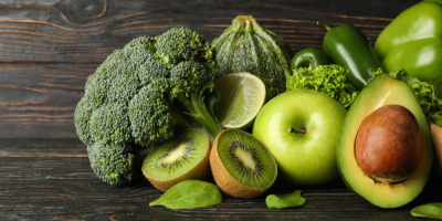 Zelená zelenina a ovoce na dřevěném pozadí