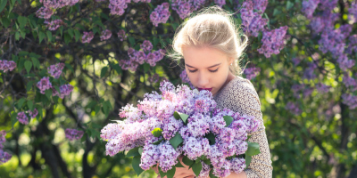Mladá žena čichá ke kytici šeříku