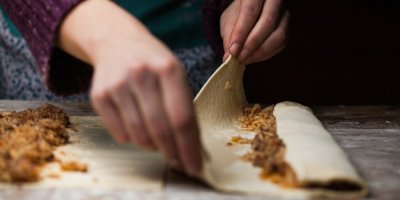 Detailní záběr na ženské ruce rolující listové těsto