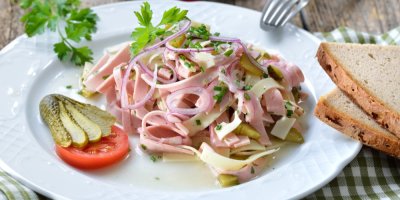 Nakrájený gothaj s proužky sýra a okurkou, podávaný s rustikálním selským chlebem