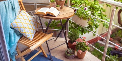 Balkónek s židlí, stolečkem, květinami, dekou a kobercem