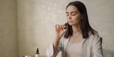 Žena zasněně čichá k vůni esenciálního oleje