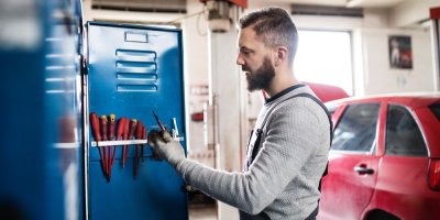 Muž u kovové skříňky v garáži