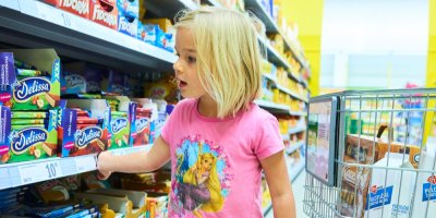 Holčička u regálu s cukrovinkami