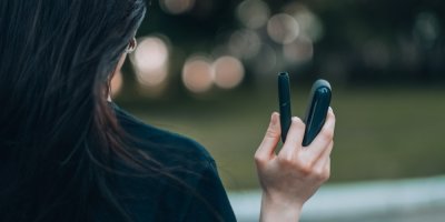 Žena drží zařízení na nahřívaný tabák