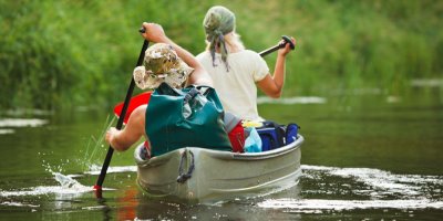 Dva lidé na kánoi plující po řece