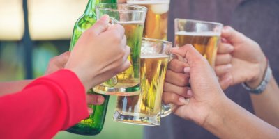 Parta lidí si připíjí s pivními flaškami a sklenicemi s pivem