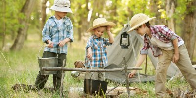 Tři kluci vaří něco v kotlíku
