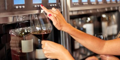 Záběr na ženské ruce, které čepují červené víno