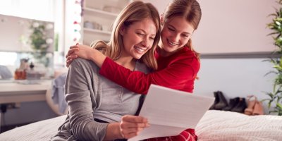 Žena s dcerou se dívají na výsledky vysvědčení