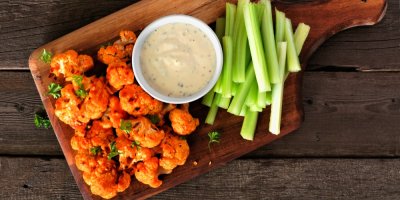 Domácí dip v misce, vedle je řapíkatý celer a opečený květák