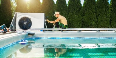 Muž instaluje tepelné čerpadlo u bazénu