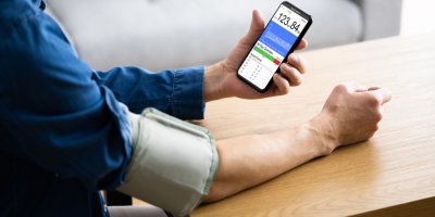 Muž si měří tlak chytrým tlakoměrem