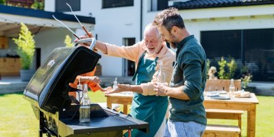 Otec se synem stojí před grilem