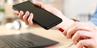 Člověk dává mobil na nabíječku