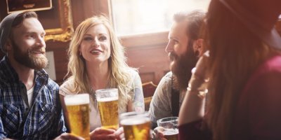 Dva muži a dvě ženy pijí pivo v hospodě