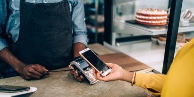 Člověk platí mobilním telefonem v cukrárně