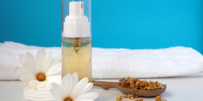 Domácí pleťová voda, sušený heřmánek, ručník, vatové tamponky, květiny