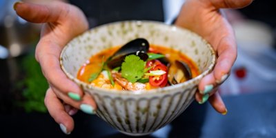 Žena drží polévku Tom Yum