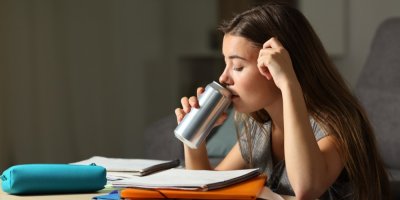 Dívka pije energetický nápoj při učení