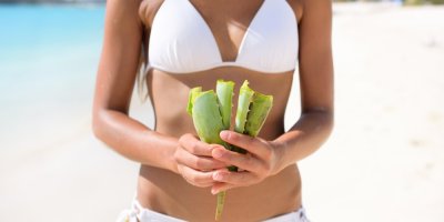 Člověk v plavkách drží aloe vera