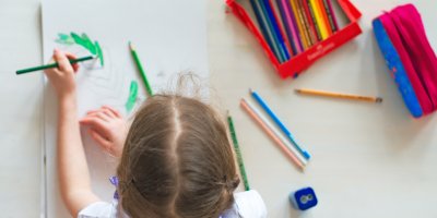 Dívka vybarvuje obrázek pastelkami