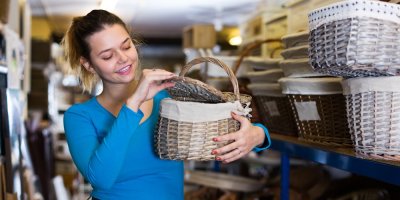 Člověk si prohlíží proutěný piknikový koš v obchodě