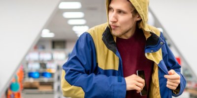 Zloděj v obchodě krade telefon