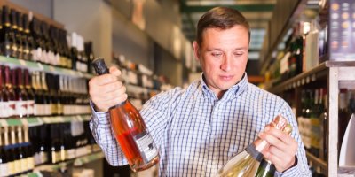 Muž nakupuje víno v obchodě