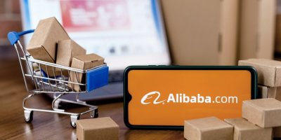 Telefon s aplikací Alibaba u malého nákupního košíku