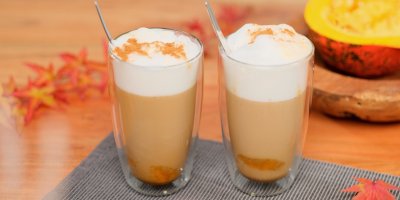 Dýňové latte macchiato na stole s podzimní dekorací 