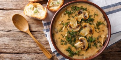 Houbová omáčka v misce a dřevěná lžíce vedle